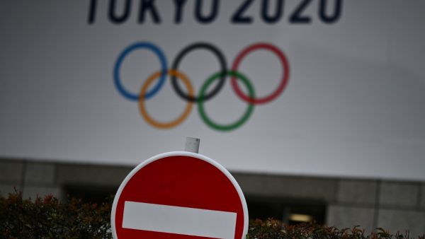 The Tokyo 2020 logo is pictured next to a "do not enter" street sign in Tokyo on March 23, 2020. CHARLY TRIBALLEAU / AFP