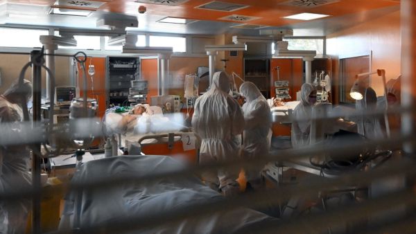 Medical workers in protective gear tend to patients (Rear L and Rear R) on March 24, 2020 at the new COVID 3 level intensive care unit for coronavirus COVID-19 cases at the Casal Palocco hospital near Rome, during the country's lockdown aimed at stopping the spread of the COVID-19 (new coronavirus) pandemic. Alberto PIZZOLI / AFP