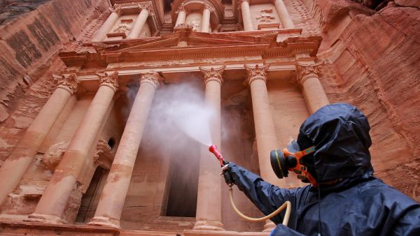A labourer sprays disinfectant in Jordan's archaeological city of Petra south of the capital Amman on 17 March, to prevent the spread of Covid-19 (AFP)