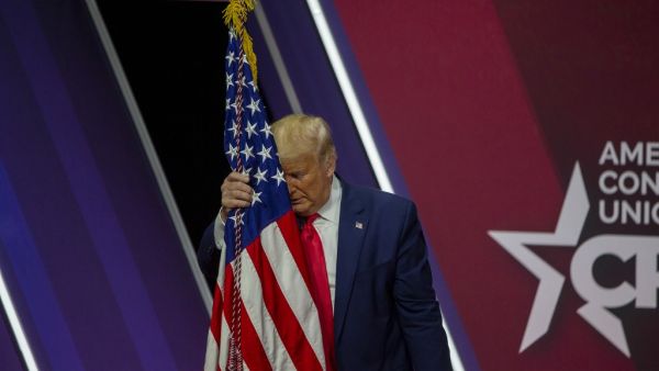 President Donald Trump rests his head on the flag of the United States of America at the annual Conservative Political Action Conference (CPAC) at Gaylord National Resort & Convention Center February 29, 2020 in National Harbor, Maryland. TASOS KATOPODIS / GETTY IMAGES NORTH AMERICA / AFP