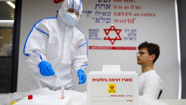 A Magen David Adom paramedic performs a coronavirus test on a volunteer at the coronavirus national operations center in Kiryat Ono, February 26, 2020. (Jack Guez/AFP)
