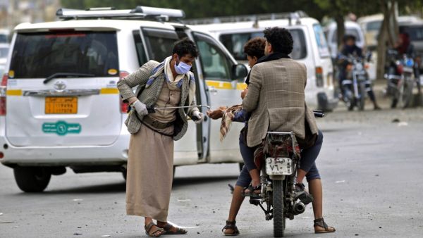 A Yemeni volunteer disinfects the hands of a man driving a motorcycle in the capital Sanaa, amid concerns over the spread of the novel coronavirus, on March 28, 2020. Yemen's broken healthcare system has not so far recorded a case of the COVID-19 illness, but aid groups have warned that when it does hit, the impact will be catastrophic in a country already regarded as facing the world's worst humanitarian crisis. Mohammed HUWAIS / AFP