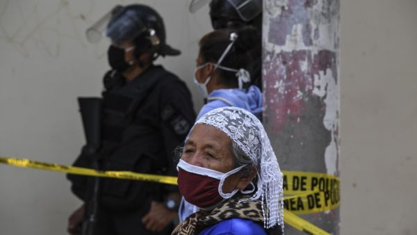 An elderly woman wears a face mask against the spread of the new coronavirus as he queues to enter a bank in San Salvador on March 30, 2020. Thousands of Salvadorans in different parts of the country were desperately seeking to receive the aid of $300 from the government for the purchase of food Monday during the outbreak of the new coronavirus pandemic.  Yuri CORTEZ / AFP