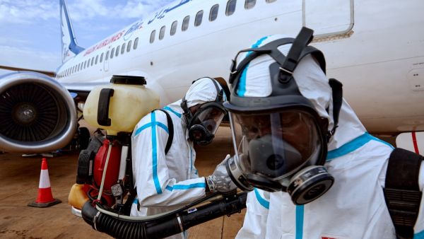 Airport staff members prepare to disinfect a plane after it landed at Juba International Airport in Juba, South Sudan on April 3, 2020. An aircraft that landed in Juba was disinfected of any potential traces of the COVID-19 coronavirus after carrying passengers who had recently arrived in South Sudan from neighbouring Sudan. Alex McBride / AFP