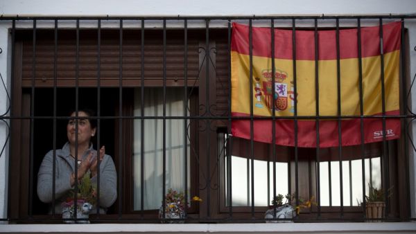 A woman applauds by her window to thank healthcare workers dealing with the COVID-19 coronavirus in Ronda on April 3, 2020 during a national lockdown to prevent the spread of the COVID-19 coronavirus. More than 900 people died in Spain over the past 24 hours for the second day running, government figures showed, although the rate of new infections and deaths continued to slow. JORGE GUERRERO / AFP