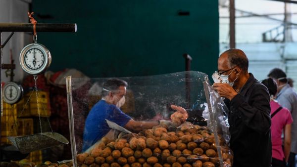 In this file photo taken on March 20, 2020, a man wears a face mask as a preventive measure against the spread of the new coronavirus, COVID-19, as he shops at a municipal market in Caracas. AFP/File