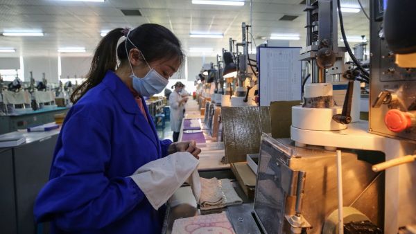 This photo taken on April 6, 2020 shows an employee working at a photoelectric production line at a factory in Wuhan in China's central Hubei province. STR / AFP