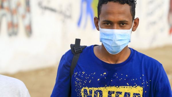 A Sudanese volunteer, wearing a protective face mask, looks at the camera in the capital Khartoum on April 8, 2020, as a group of youth clear debris from a street during a COVID-19 awareness-raising campaign. Sudan. (AFP/ File PHoto)