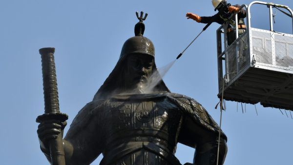 A South Korean worker sprays water to wash the bronze statue of Admiral Yi Sun-Shin, who won a major naval victory over Japan in the 16th century, during a street and park clean-up event for spring at Gwanghwamun square in Seoul on April 9, 2020. Jung Yeon-je / AFP