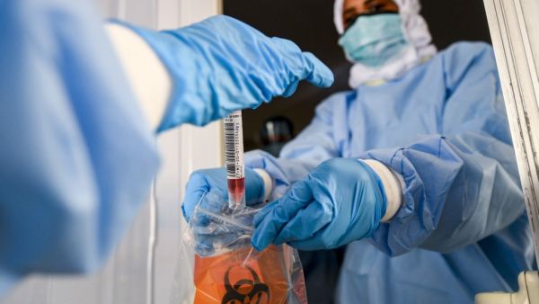 Laboratory workers bag a biological sample at a drive-through COVID-19 coronavirus testing centre in al-Khawaneej district of the gulf emirate of Dubai on April 9, 2020. KARIM SAHIB / AFP