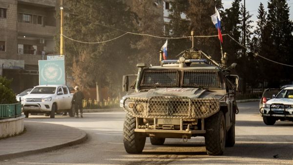 A Russian military police vehicle returning from a joint patrol with Turkish forces along the Syrian-Turkish border, drives along a roundabout near Qamishli airport in the northeastern Syrian city on April 9, 2020. Delil SOULEIMAN / AFP