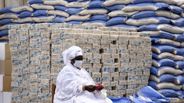 A municipal agent waits for rice bags and soap bars to be distributed by the mayor of Dakar to the residents of the19 municipalities of the Senegalese capital on April 10, 2020. SEYLLOU / AFP