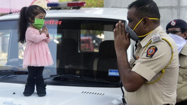 Guinness world record holder of the world's smallest living woman, Jyoti Amge (L), greets a police officer as she appeals citizens to stay inside their homes during a government-imposed nationwide lockdown as a preventive measure against the COVID-19 coronavirus, in Nagpure on April 13, 2020. STR / AFP