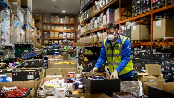 Richard Humphrey, Senior Coordinator for the charity 'His Church', helps prepare pallets of food and supplies which will be distributed to charities and community support networks across the UK from their warehouse near Market Rasen, northern England on April 14, 2020. AFP