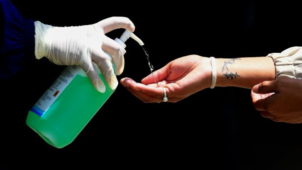 A health worker dispenses sanitizer to a person before a COVID-19 rapid test during a government-imposed nationwide lockdown as a preventive measure against the spread of the COVID-19 coronavirus, in Bungamati, Lalitpur on the outskirts of Kathmandu on April 15, 2020. PRAKASH MATHEMA / AFP
