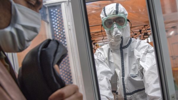 Members of the medical staff at the Mohammmed V military hospital, wearing protective outfits, receive a patient to be tested for the novel coronavirus, in the Moroccan capital Rabat on April 15, 2020 FADEL SENNA / AFP