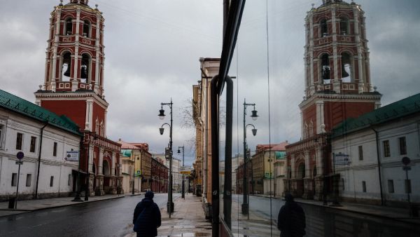 A woman walks on a deserted street past the Vysoko-Petrovsky Monastery in downtown Moscow on April 16, 2020, during a strict lockdown in Russia to stop the spread of the COVID-19 coronavirus. Dimitar DILKOFF / AFP