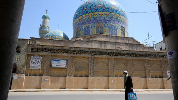 An Iraqi man walks past the closed Haydar-Khana mosque in the capital Baghdad on April 17, 2020, during the novel coronavirus pandemic crisis that urged authorities to shut down social gathering places in a bid to slow its spread among the population. AHMAD AL-RUBAYE / AFP