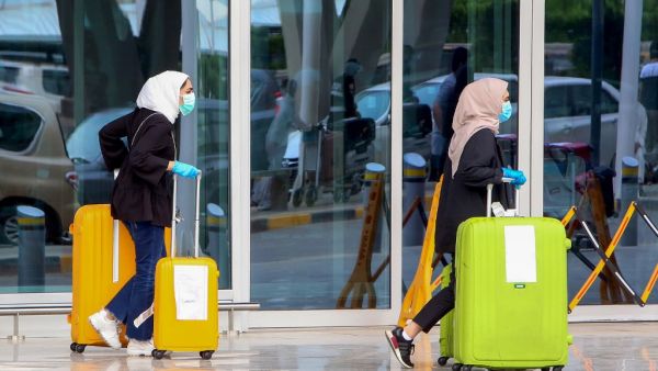 Kuwaiti nationals, residing abroad, leave the Kuwait International airport in the capital upon their return as part of a repatriation plan on April 19, 2020, and ahead of being taken to mandatory home quarantine. YASSER AL-ZAYYAT / AFP