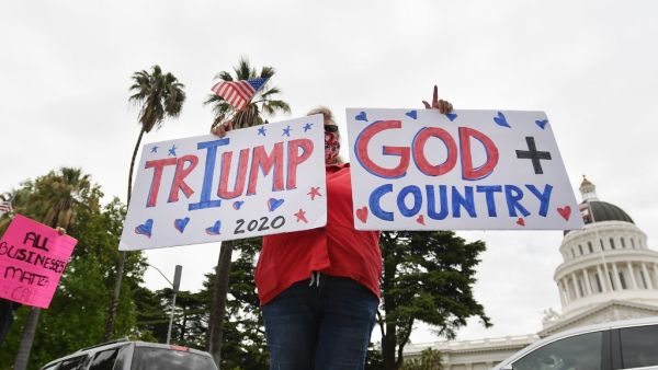 Some people intentionally jammed roads while honking and holding out signs while others disrespected social distancing rules by gathering in close proximity, blaring Americana music and shouting to end the lockdown. Josh Edelson / AFP