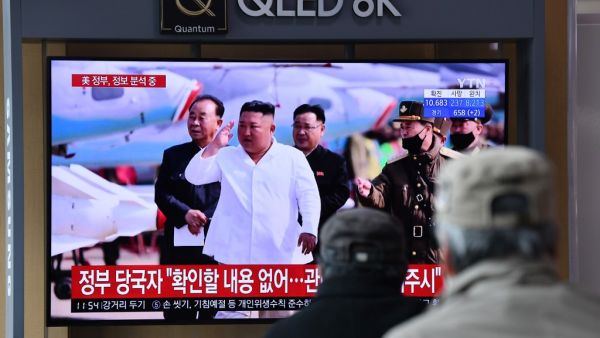 People watch a television news broadcast showing file footage of North Korean leader Kim Jong Un, at a railway station in Seoul on April 21, 2020. South Korea played down a report on April 21 that the North's leader Kim Jong Un was being treated after surgery, as speculation mounted over his absence from a key anniversary. Jung Yeon-je / AFP