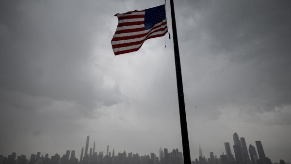 An US flag flies at half-mast half mast in front of the Skyline of Manhattan of New York City seen from Weehawken, New Jersey, on April 21, 2020. Over 2.5 million people have been confirmed to have contracted the coronavirus worldwide, with 80 percent of cases in Europe and the United States, according to an AFP tally Tuesday based on official figures. Johannes EISELE / AFP