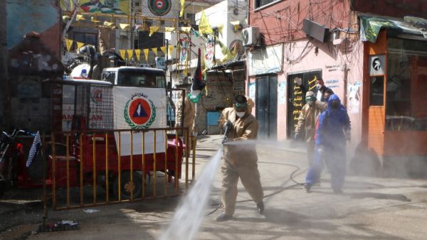 Workers disinfect the Wavel camp (also known as the Jalil Camp) for Palestinian refugees in Lebanon's eastern Bekaa Valley, on April 22, 2020, after the UN announced the first confirmed case of coronavirus there. The patient, a Palestinian refugee from Syria, has been taken to the Lebanese state-run Rafiq Hariri hospital in Beirut, UNRWA, the UN agency for Palestinian refugees, said in a statement on April 21. More than 2,000 people live in Wavel, according to statistics released by Lebanons' government aft