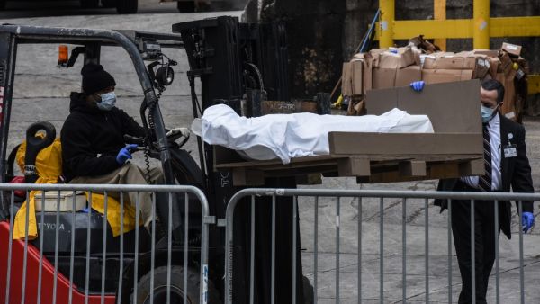 A worker uses a forklift to move a body outside of the Brooklyn Hospital on March 31, 2020 in New York, United States. Due to a surge in deaths caused by the Coronavirus, hospitals are using refrigerator trucks as make shift morgues. Stephanie Keith/Getty Images/AFP STEPHANIE KEITH / GETTY IMAGES NORTH AMERICA / Getty Images via AFP