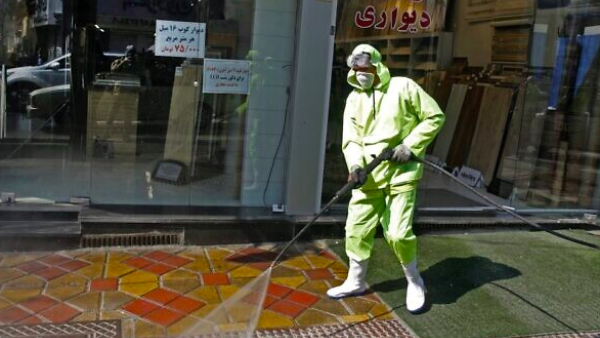 Iranian fire fighters and municipality workers disinfect a street in the capital Tehran for corona virus COVID-19 on March 5, 2020 (STR / AFP)