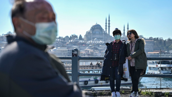 Tourists with facemasks at the Istanbul’s Galata Bridge, 13 March 2020 (AFP Photo)