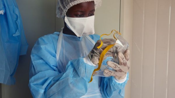 Medical staff of International Medical Corps (IMC) put on Personal Protective Equipment (PPE) at the isolation ward of Ministry of Health Infectious Disease Unit in Juba, South Sudan, on April 24, 2020. The national facility hosts South Sudan’s fifth case of the COVID-19 Coronavirus, who was admitted yesterday. Alex McBride / AFP