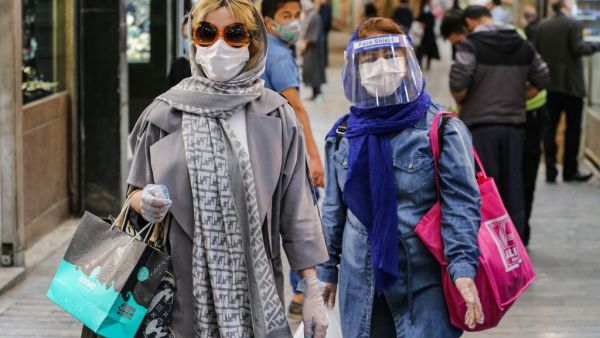 Shoppers clad in protective gear, including face masks and shields and latex gloves, due to the COVID-19 coronavirus pandemic, walk through the Tajrish Bazaar in Iran's capital Tehran on April 25, 2020 during the Muslim holy month of Ramadan. ATTA KENARE / AFP