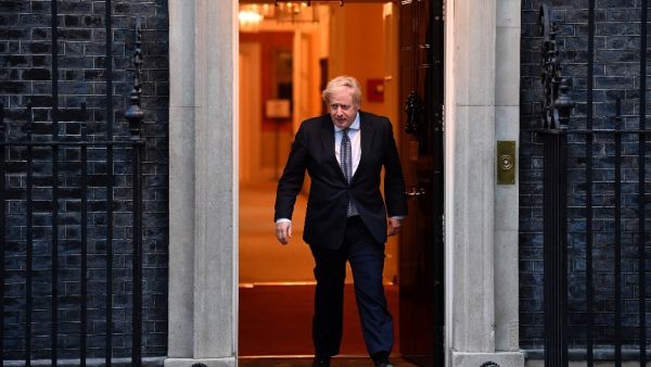Britain's Prime Minister Boris Johnson walks of 10 Downing Street in central London on April 30, 2020, to participate in a national "clap for carers" to show thanks for the work of Britain's NHS (National Health Service) workers and other frontline medical staff around the country as they battle with the novel coronavirus pandemic, in the doorway of ˜Britain is "past the peak" of its coronavirus outbreak, Prime Minister Boris Johnson said Thursday, despite recording another 674 deaths in the last 24 hours, 