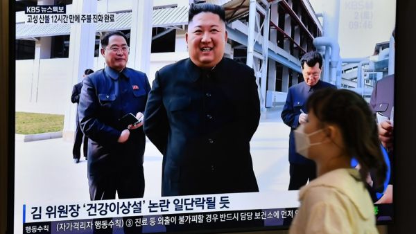 A woman walks past a television news screen showing a picture of North Korean leader Kim Jong Un attending a ceremony to mark the completion of Sunchon phosphatic fertiliser factory, at a railway station in Seoul on May 2, 2020. North Korea's Kim Jong Un has made his first public appearance in nearly three weeks, state media reported on May 2, following intense speculation that the leader of the nuclear-armed nation was seriously ill or possibly dead. Jung Yeon-je / AFP