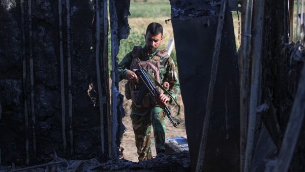 An Iraqi fighter with the Hashed al-Shaabi (Popular Mobilisation Forces) inspects the site of the Islamic State (IS) group attack, a day earlier, on a unit of the paramilitary force in Mukaishefah, about 180km (110 miles) north of the capital, on May 3, 2020. IS group remnants in Iraq are exploiting a coronavirus lockdown, coalition troop withdrawals and simmering political disputes to ramp up deadly attacks, according to analysts and intelligence officials, the bloodiest so far being an ambush early on May