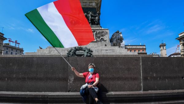 A woman waves the Italian flag on May 4, 2020 in Milan as Italy starts to ease its lockdown, during the country's lockdown aimed at curbing the spread of the COVID-19 infection, caused by the novel coronavirus. AFP/File