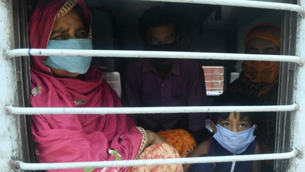 Migrant labourers with their family members sit near a train window as they arrive from the Western Indian state of Rajasthan through a special train organised to bring back migrant labourers and pilgrims to their hometowns at the Dankuni Railway station after the government eased a nationwide lockdown imposed as a preventive measure against the COVID-19 coronavirus, some 25 Km north of Kolkata on May 5, 2020. Dibyangshu SARKAR / AFP