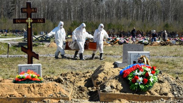 Cemetery workers wearing protective gear bury a coronavirus victim at a cemetery on the outskirts of Saint Petersburg on May 6, 2020. OLGA MALTSEVA / AFP