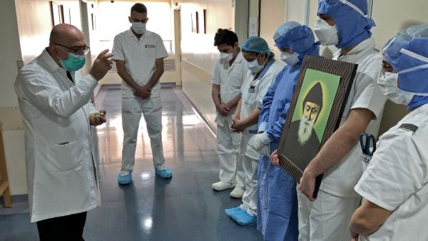 A picture taken by a nurse on April 9, 2020 at the Hotel Dieu de France Hospital, colleagues gathered for a prayer guided by a priest in the coronavirus COVID-19 section of the hospital, in the neighbourhood of Ashrafieh of the Lebanese capital Beirut's eastern suburbs. (AFP)