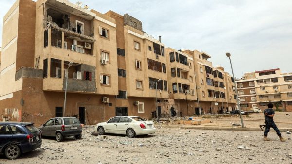 A fighter loyal to Libya's UN-recognised Government of National Accord (GNA) walks through debris along a street near a destroyed apartment balcony, following bombardment earlier in the day in the residential Bab Bin Ghashir neighbourhood of Libya's capital Tripoli, on May 9, 2020. Prior rocket and shell fire on Tripoli had killed at least 13 civilians and two policemen, Libya's UN-recognised government said on May 8. The GNA accused forces loyal to strongman Khalifa Haftar of carrying out the attacks, whic
