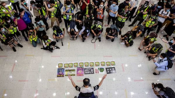 Journalists watch a pro-democracy demonstrator protests calling for the city's independence in Hong Kong on May 10, 2020. ISAAC LAWRENCE / AFP