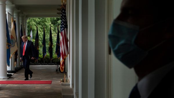 A member of the Secret Service wears a surgical mask as US President Donald Trump arrives for a news conference on the novel coronavirus, COVID-19, in the Rose Garden of the White House in Washington, DC on May 11, 2020. Brendan Smialowski / AFP