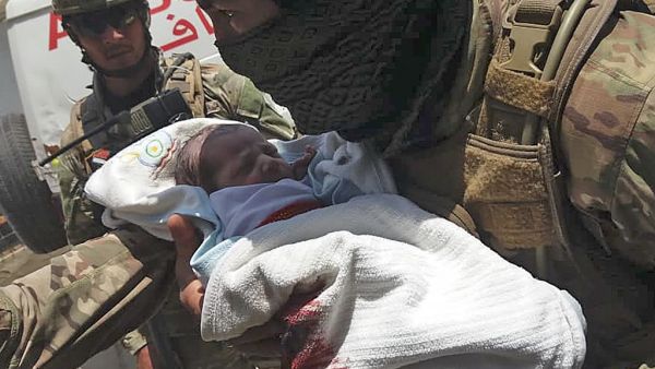 An Afghan security personnel carries a newborn baby from a hospital, at the site of an attack in Kabul on May 12, 2020. Gunmen stormed a hospital on May 12 in an ongoing attack in the Afghan capital Kabul, a government official and a fleeing doctor said. STR / AFP
