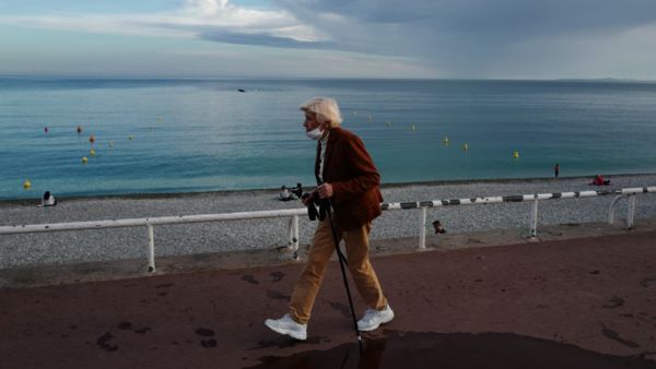 A woman walks on the "Promenade des anglais" in the French riviera city of Nice, southern France, on May 17, 2020, as France eases lockdown measures taken to curb the spread of the COVID-19 pandemic, caused by the novel coronavirus. Some beaches on the Mediterranean coast will re-open after two months of coronavirus lockdown, but will be reserved only for swimming and walking. VALERY HACHE / AFP