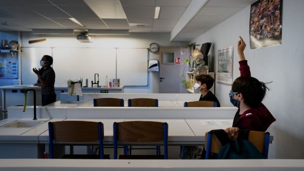 Schoolchildren wearing protective face masks attend a lesson in a middle school classroom, on May 18, 2020 in Lyon, central eastern France, after France eased lockdown measures to curb the spread of the COVID-19 pandemic, caused by the novel coronavirus. JEFF PACHOUD / AFP