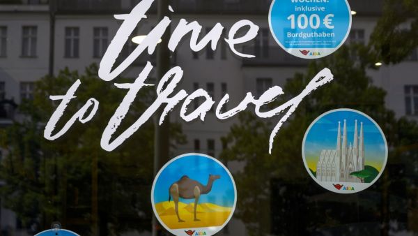 "Time to Travel" is written on the window of a travel agency on May 18, 2020 in Berlin amid the novel coronavirus COVID-19 pandemic. To halt transmission of the coronavirus, many countries have slammed borders shut and banned tourism, leaving planes grounded and cruise ships idle at ports while hotels are left empty. John MACDOUGALL / AFP