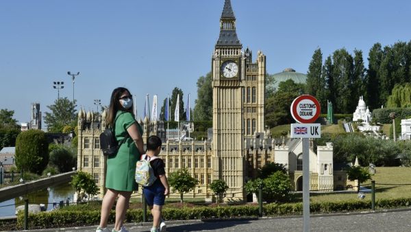 A model of a customs road sign is seen at the mock border of the United Kingdom and the European Union, a visitors look at a model of Big Ben, during the reopening of the 'Mini-Europe' theme park of small-scale models of European capitals and their landmarks, in Brussels on May 20, 2020. JOHN THYS / AFP