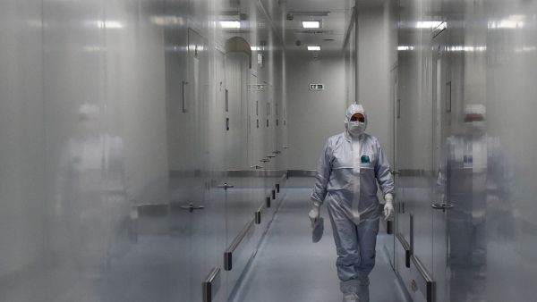 An employee wearing protective equipment walks in a passage at the headquarters of Russia's biotech company BIOCAD, which is developing its own vaccine against the new coronavirus and working on another one in cooperation with the country's virus research centre in Siberia, Vektor, in Strelna on May 20, 2020. OLGA MALTSEVA / AFP