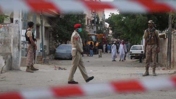 Security personnel patrol on a cordon off a street a day after a Pakistan International Airlines aircraft crashed in a residential area in Karachi on May 23, 2020. Ninety-seven people were killed and two survived when a passenger plane crashed into homes in Pakistan's southern city of Karachi, health officials said on May 23. Asif HASSAN / AFP