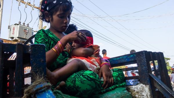 A girl holds a baby at the Aung Mingalar quarter for Rohingya Muslims as they observe the first day of the Eid al-Fitr holiday, which marks the end of the Islamic holy month of Ramadan, in Sittwe, Myanmar's Rakhine State on May 24, 2020. AFP